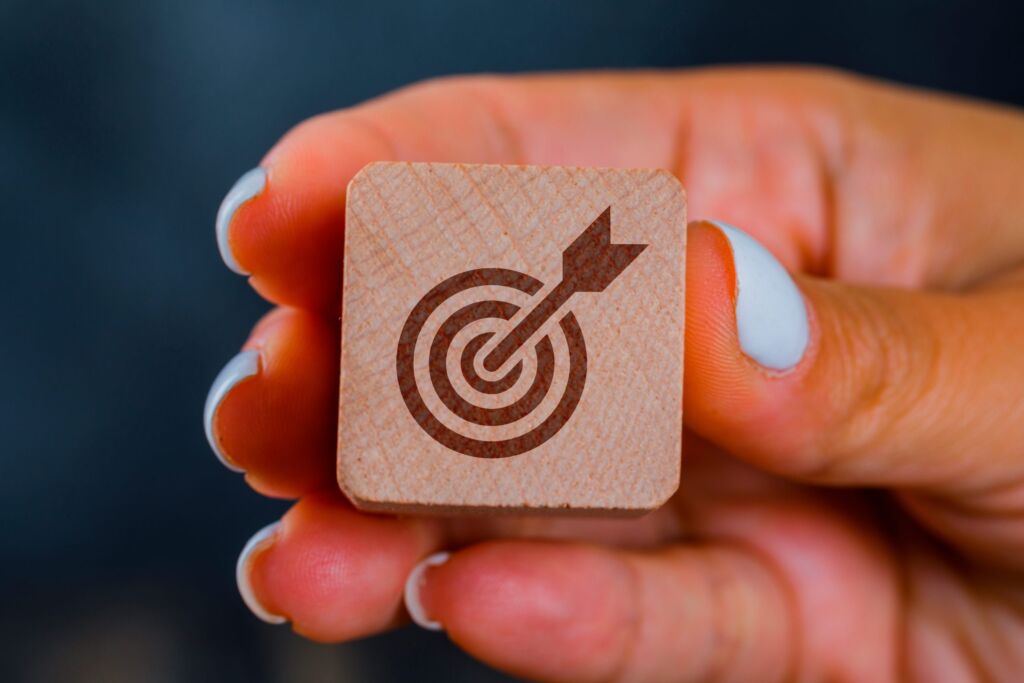 Possibilita clientes mais qualificados : uma m&atilde;o segurando um alvo em uma pe&ccedil;a de madeira