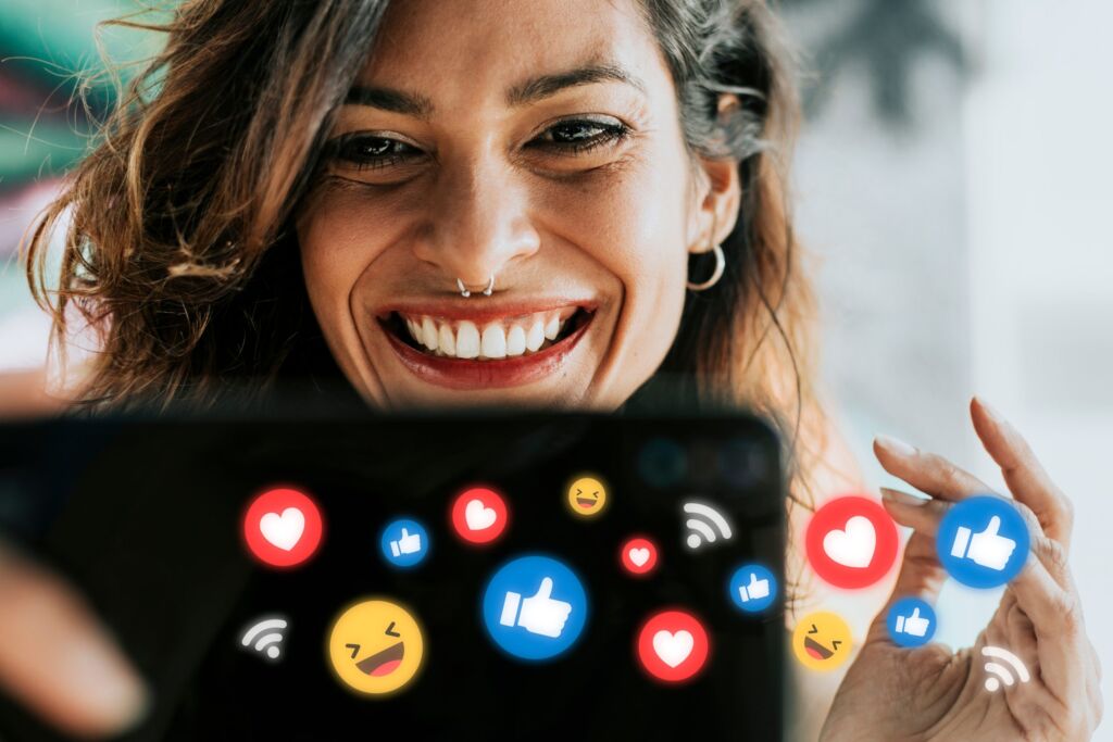 Significado de influenciar : uma pessoa alegre usando um tablet circundado por &iacute;cones de redes sociais
