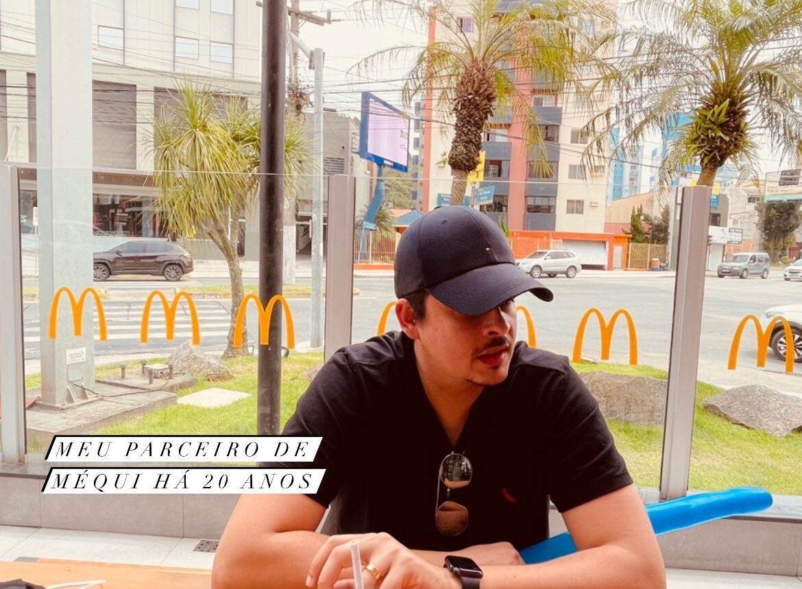 Influencer masculino sentado em uma mesa do Mcdonalds