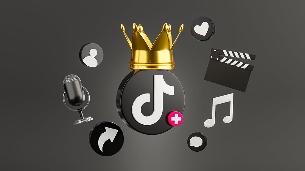 O que &eacute; o TikTok? : &iacute;cone do tiktok em 3d centralizado com uma coroa dourada acima dele e v&aacute;rios outros &iacute;cones de suas fun&ccedil;&otilde;es em volta dele