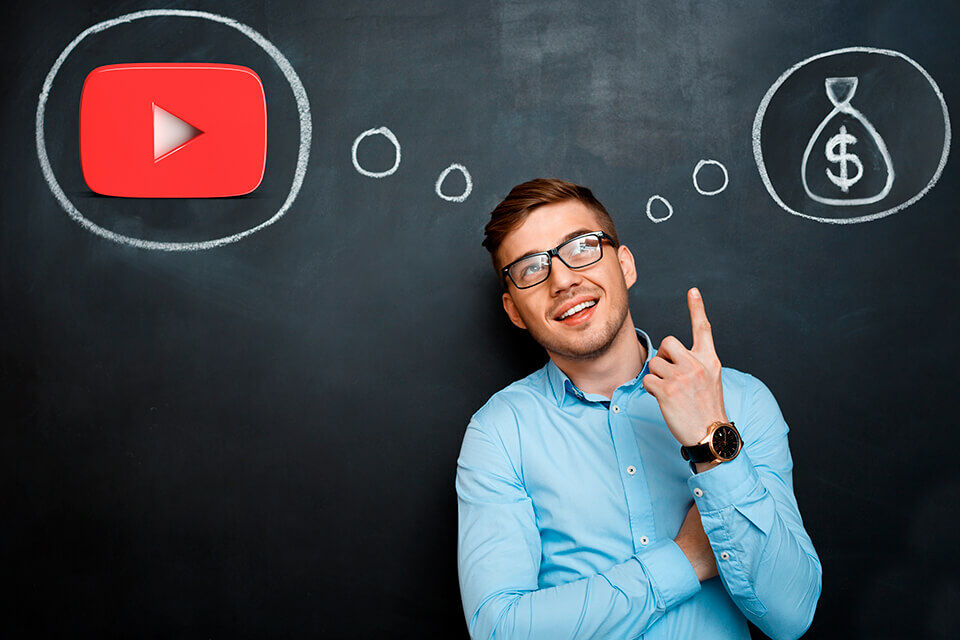 Rapaz de frente um quadro escolar pensando em um ícone do youtube e um pacote de dinheiro desenhado a giz