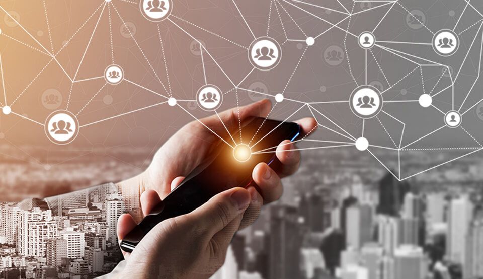 Mãos segurando celular e dele saindo uma luz que dando ideia de muitos compartilhamentos