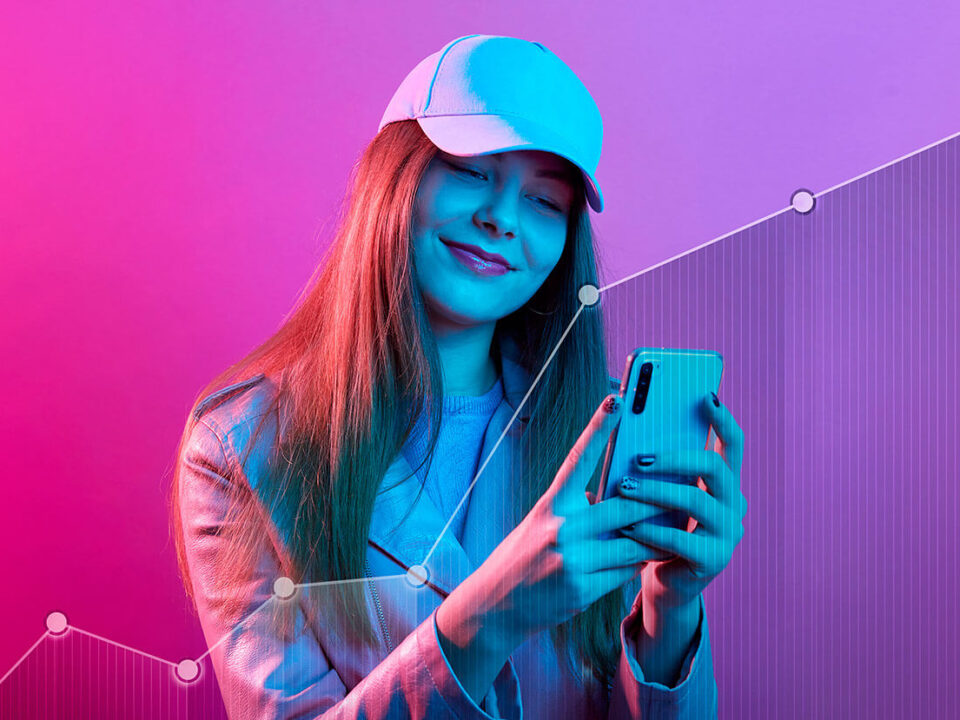 Foto rosada de uma influencer de boné com um celular nas mãos e em sua frente um gráfico em sentido de crescimento, representando as tendências para o marketing de influência em 2023. Foto: @Freepik